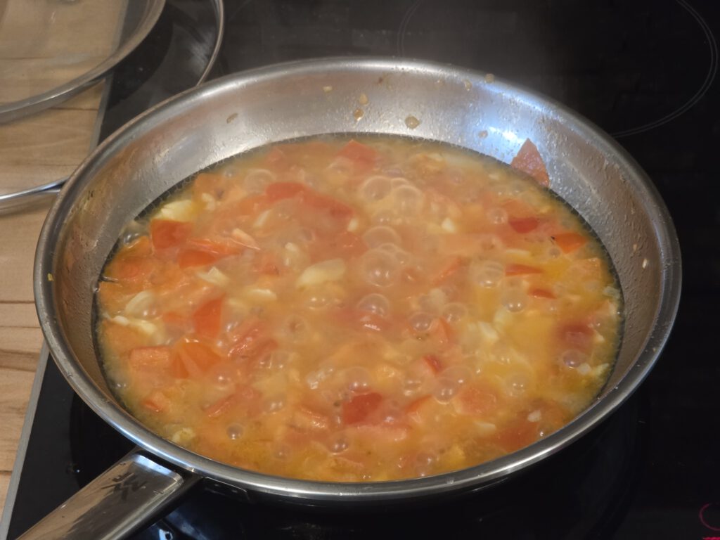 Spargelstücke mit Tomaten, Zwiebel und Knoblauch in Butter und Nudelwasser